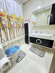 bagno con lavandino, servizi igienici e specchio di Holiday triplex house a Gabès