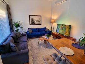 a living room with a blue couch and a table at Suelo Flat Villa in Turgutreis +24 photos