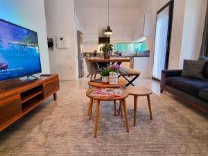 a living room with a tv and a couch and a table at Suelo Flat Villa in Turgutreis