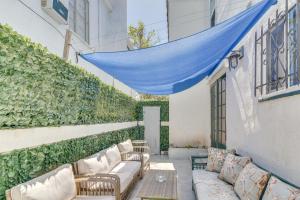 a patio with couches and a blue canopy at Upscale Los Angeles Retreat with Patio and BBQ Grill! in Los Angeles