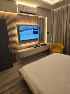 a hotel room with a bed and a flat screen tv at Yasmine in Dammam