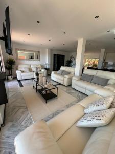 a large living room with white couches and a table at Luxury villa in the heart of the city of Marbella Spain. in Marbella