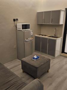 a living room with a kitchen with a microwave at شقق ياسمين عمارة سكنية in Dammam
