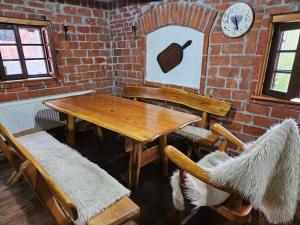 - une table et des chaises en bois dans une chambre dotée d'un mur en briques dans l'établissement Vikendica Bajka, à Despotovac