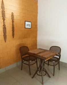 uma mesa de madeira e duas cadeiras ao lado de uma parede em Espaço Ecológico Bosque Ava em Cavalcante