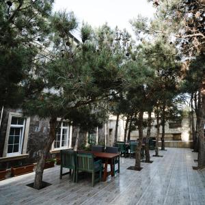 a courtyard with tables and chairs and trees at Avrasya Hotel in Baku