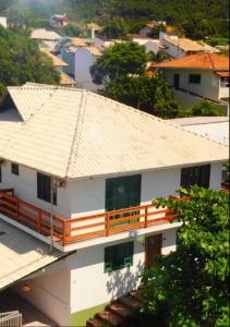 ein weißes Haus mit einem orangenen Geländer darüber in der Unterkunft Pousada Makani Kai in Florianópolis