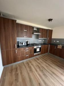 a kitchen with wooden cabinets and a wooden floor at Down Town Pad*2Bed&Free Parking* in Glasgow