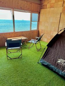 Zimmer mit einem Zelt, einem Tisch und Stühlen in der Unterkunft ASTERISK＋ in Iwami