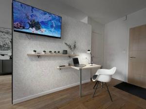 Zimmer mit einem Schreibtisch und einem Computer an der Wand in der Unterkunft Grand studio confortable situé en centre ville in Gérardmer