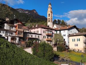 a town in the mountains with a clock tower at Casa Micéi in Tesero