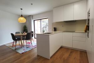 a kitchen with white cabinets and a table with chairs at Quinta do Penedo Real in Viana do Castelo