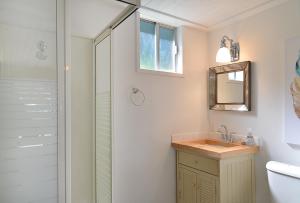 a bathroom with a shower and a sink and a mirror at John Henry's Marina and Resort in Garden Bay