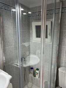 een badkamer met een douche, een toilet en een wastafel bij Διαμέρισμα με βεράντα δίπλα στα ΜΜΜ in Athene