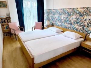 - une chambre avec un lit et deux chaises roses dans l'établissement Athens Parrot, à Athènes