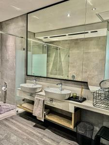 a bathroom with two sinks and a large mirror at The RoyalPlatinum Penthouse in Johannesburg