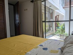 uma cama num quarto com uma grande janela em Hermoso Departamento De Lujo em Lima