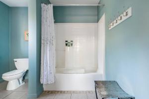 y baño con ducha, aseo y bañera. en Serene Retreat on a Stream en Phoenicia