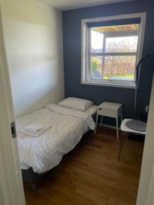 a small bedroom with a bed and a window at Koselig og rolig leilighet med utsikt nær Preikestolen in Strand