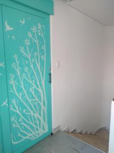 a blue door with a tree mural on it at Céntrica y confortable habitación in Oaxaca City