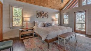 a bedroom with a bed and a table and windows at Seven Turns to Sunrise in Blue Ridge