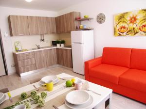 een woonkamer met een rode bank en een tafel bij Casa Tomani in Grado