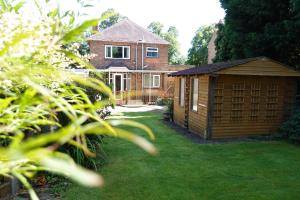 a house with a small shed in the yard at Large 4 Bed House, Sleeps 7, Near NEC, BHX, City Centre in Birmingham