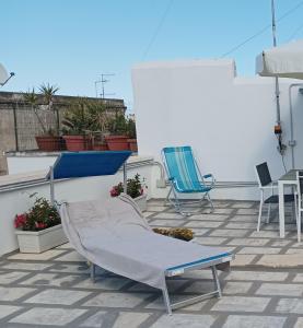 eine Terrasse mit 2 Stühlen und einem Tisch auf dem Dach in der Unterkunft B&B Ninedda in Monopoli