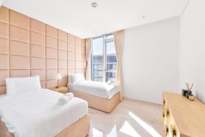 ein Hotelzimmer mit 2 Betten und einem Fenster in der Unterkunft Premium 2+1 BR condo in the heart of Bluewaters Island in Dubai