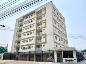 a tall white building with a fence in front of it at Residencial renaissance in Boa Vista