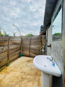 a bathroom with a sink next to a fence at Ego Swargarajje Yala Thissamaharama in Tissamaharama
