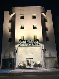 un gran edificio con un cartel para un hotel de garaje en فندق غسن (الإسكان) en Medina