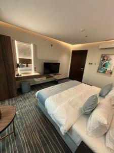 Habitación de hotel con cama grande y TV en فندق غسن (الإسكان) en Medina