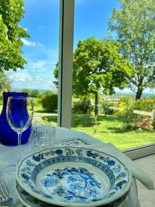 un tavolo con un piatto blu e bianco e un bicchiere di Villa degli Olmi a Castel San Pietro Terme