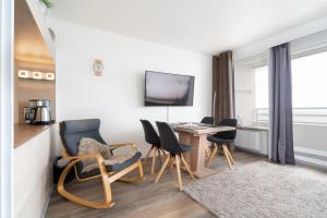 a living room with a table and chairs and a desk at Ferienpark Sierksdorf App 347 - Strandlage in Sierksdorf