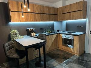 a kitchen with wooden cabinets and a table and a sink at KA apartment Luxury in Stara Zagora