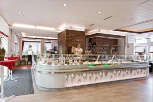 a woman standing behind a counter in a store at Hotel Restaurant Ketterer am Kurgarten in Triberg