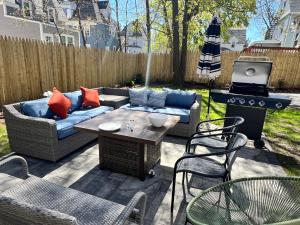 a patio with a couch and a table and a grill at Harvrd-MIT-B.U./Parkfree/Single Family residence in Boston