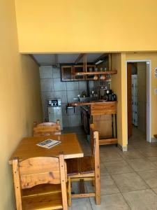 a kitchen with a wooden table and wooden chairs at Camping El Bolsón in El Bolsón