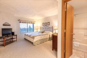 una camera con letto, televisore e finestra di Seven Springs Meadowridge 2 Bedroom Standard Condo with Deck and Mountain Views! condo a Champion
