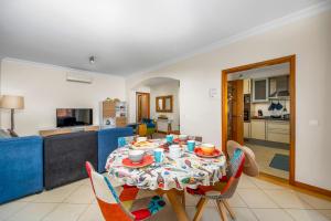 a dining room table with chairs and a kitchen at Avenue Apartment Vilamoura in Quarteira