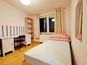 sypialnia z łóżkiem, biurkiem i oknem w obiekcie Villa Karolina w Krakowie