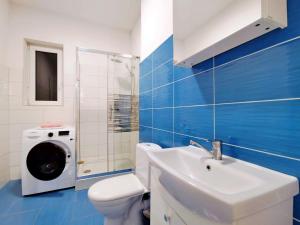 łazienka z umywalką i pralką w obiekcie Villa Karolina w Krakowie