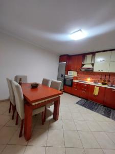 eine Küche mit einem Holztisch und Stühlen in der Unterkunft GEX Guest House in Tirana