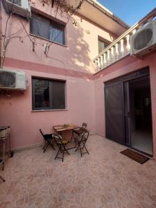 une terrasse avec une table et des chaises devant un bâtiment dans l'établissement GEX Guest House, à Tirana