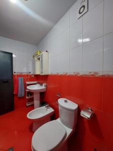 GEX Guest House في تيرانا: حمام احمر مع مرحاض ومغسلة