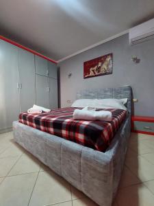 - une chambre avec un grand lit et une couverture tressée dans l'établissement GEX Guest House, à Tirana