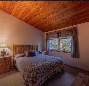 een slaapkamer met een groot bed en een houten plafond bij Cabin in Remer in Remer