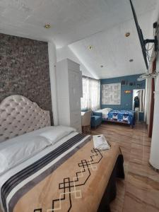 1 dormitorio con 1 cama grande y sala de estar en Hostal COLUMBIA, en Moquegua