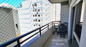 - Balcón de un edificio con mesa y sillas en Centro Guarapari - espaço & conforto - WI-FI en Guarapari